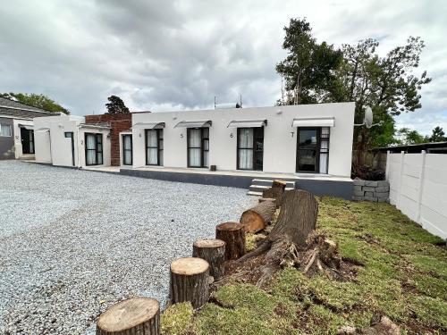 a white house with logs in front of it at 19 on Gordon in East London