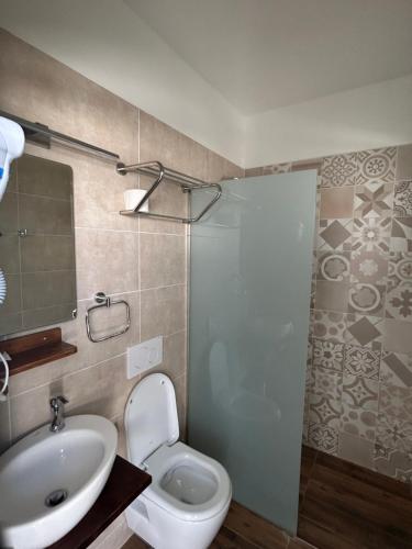 a bathroom with a sink and a toilet and a shower at Leventis Studios 2 in Faliraki