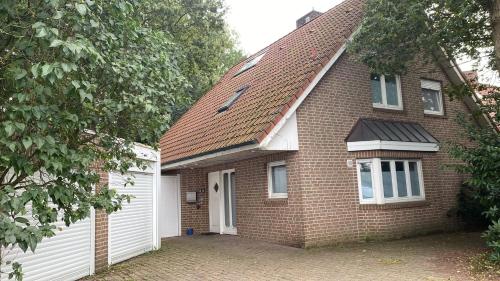a brown brick house with a white garage at Gästehaus am Biener See in Schepsdorf