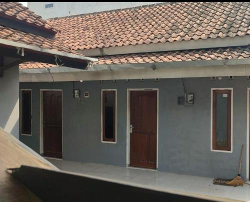 a house with brown doors and a roof at Reza Kost in Karanganyar