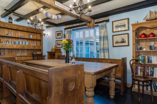una sala da pranzo con tavolo e sedie in legno di Historic Osborne House very close to the beach a Looe