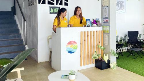 two women standing at a counter in a office at Happy Island Inn in Virac