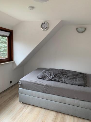 Bett in einem Zimmer mit einer Uhr an der Wand in der Unterkunft MyCha2 Ferienhaus in Goslar