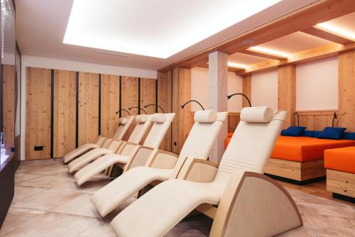 a row of chairs in a room with wood paneling at Hotel Neuhintertux 4 Sterne superior in Tux