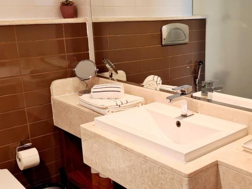 a bathroom with a sink and a mirror at A Perfect Escape - Sea facing in Ras al Khaimah