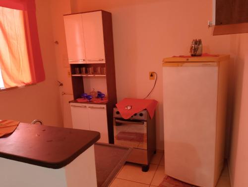 a small kitchen with a refrigerator and a table at Apartamento Padrão 1° andar in Vespasiano