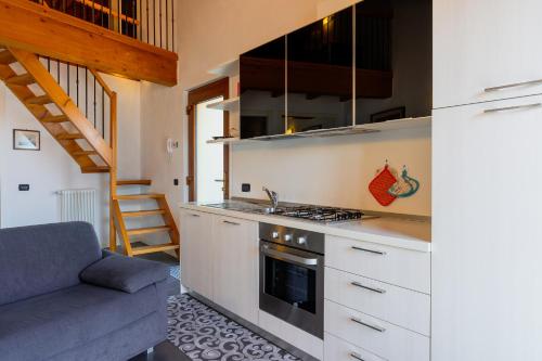 a kitchen with a stove top oven next to a couch at Casa Fausto in Vercana