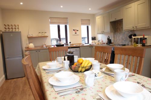 a kitchen with a table with a bowl of fruit on it at Moo Cow Cottage Self Catering in Oakham
