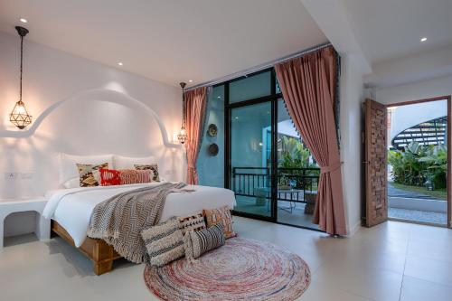 a bedroom with a large bed and a balcony at 花语岸·度假酒店(H·Flora Hotel) in Chiang Mai