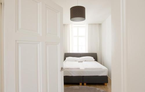 a bedroom with a bed with white sheets and a window at MINIMALISTIC STUDIO NEAR NASCHMARKT in Vienna