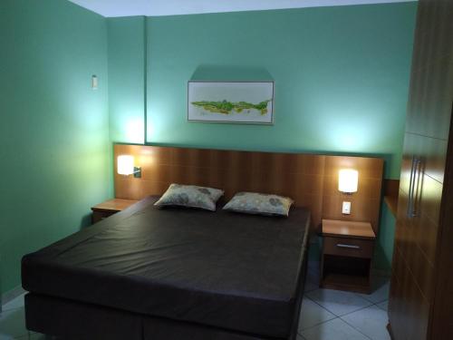 une chambre avec un lit avec deux oreillers dessus dans l'établissement 1403 AP 2 Quartos , banheira de hidro privativa, bebidas liberadas nas piscinas , internet no ap, proximo ao shopping singapura, à Caldas Novas