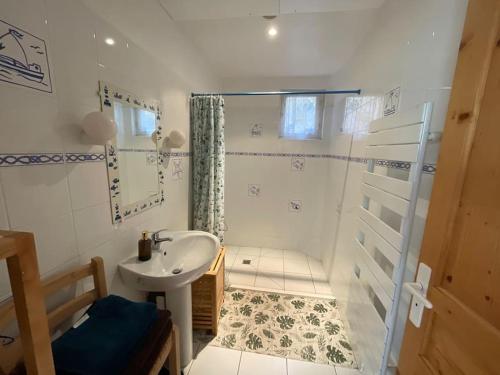 une salle de bain avec un lavabo et une douche dans l'établissement Flat in a unique location 30 m from the beach with terrace and garden, à Carnac