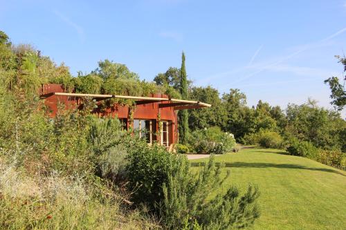a house in the middle of a field with trees at Wine Loft in Bagno Vignoni