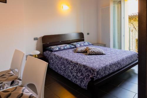 a bedroom with a bed with a purple comforter at Casa Fausto in Vercana