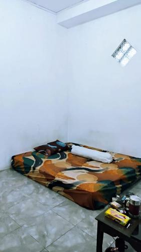 Bett in einem Zimmer mit Wandgemälde in der Unterkunft Reza Kost 