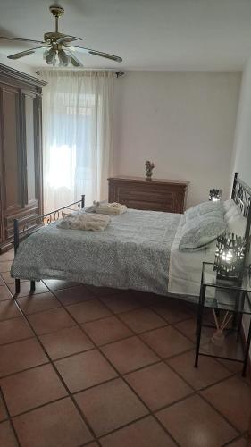 a bedroom with a bed and a ceiling fan at La casa nel borgo in Bracciano