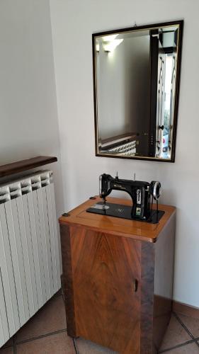 una máquina de coser sobre una mesa de madera con un espejo en La casa nel borgo en Bracciano
