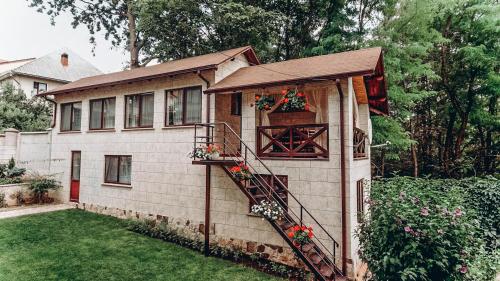 uma casa com uma escada em espiral ao lado dela em White Valley entire Guest House next to Forest em Chişinău