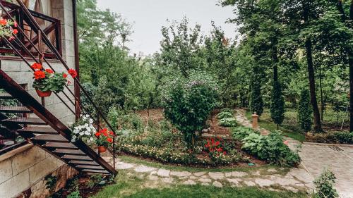 a garden with flowers on the side of a house at White Valley entire Guest House next to Forest in Chişinău