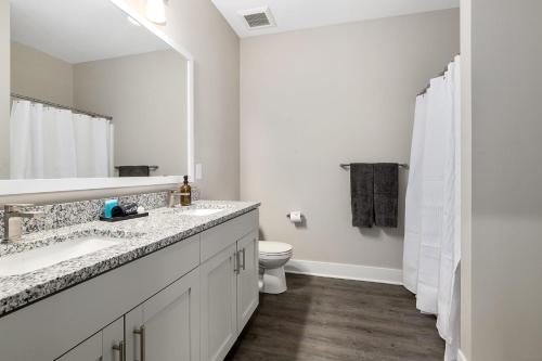 a white bathroom with a sink and a toilet at Modern 2BR 2BA New Build Condo with Garage & Patio in Wyoming