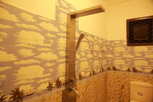 a bathroom with a mural of clouds and palm trees at Villa71 in Galle