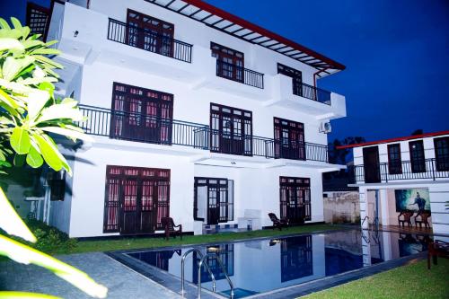 a white building with a pool in front of it at Villa71 in Galle