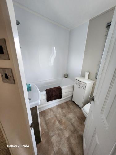 a bathroom with a tub and a toilet and a sink at Seaview in Leysdown-on-Sea