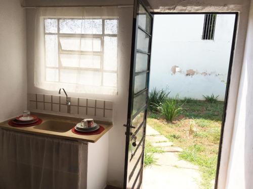 a kitchen with a sink next to a window at Loft Sousas in Campinas