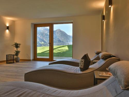 a bedroom with two beds and a large window at Natur Residence Kaiser Hans in Schenna