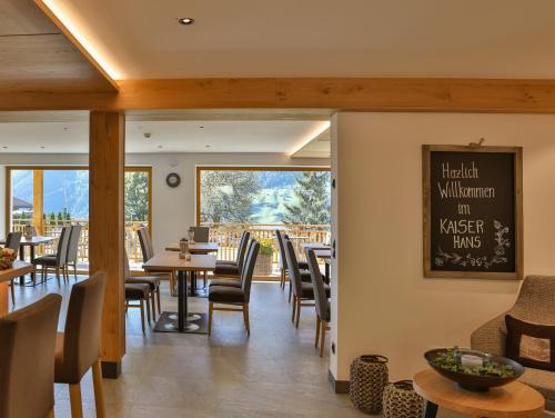 a restaurant with tables and chairs and a large window at Natur Residence Kaiser Hans in Schenna