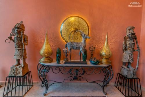 a table with a clock and statues on it at Palais Hassoun Marrakech in Oulad Snaguia