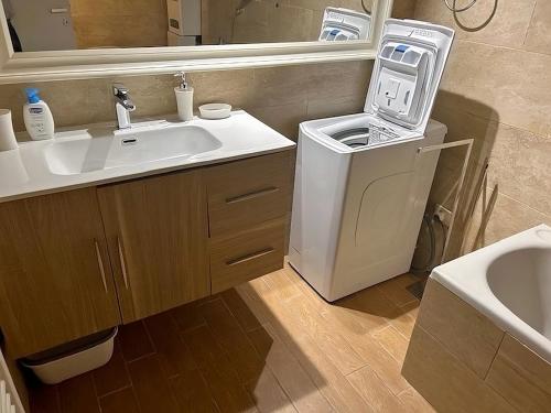 een badkamer met een wastafel en een wasmachine bij DOLCEVITA PONTE MILVIO in Rome