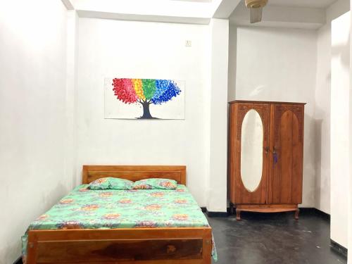 a bedroom with a bed and a painting on the wall at Mirana Guest in Weligama