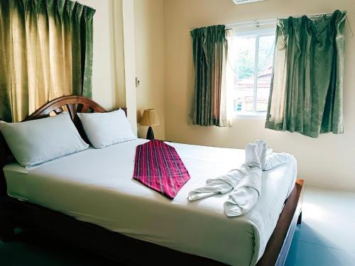 a bed with a pair of shoes sitting on it at Khao-Sok Bed and Breakfast in Khao Sok National Park