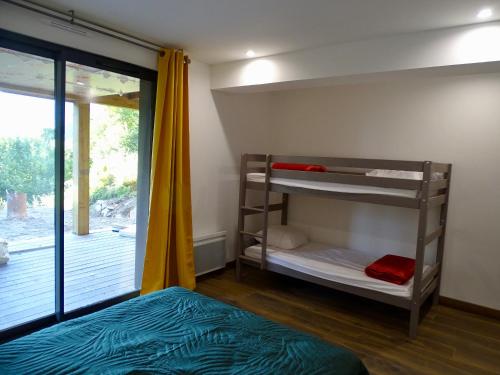 Schlafzimmer mit Etagenbetten und Glasschiebetür in der Unterkunft Appartement 14 personnes in Ax-les-Thermes