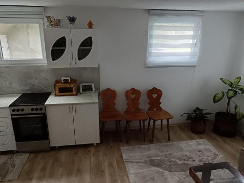a kitchen with white cabinets and a table and chairs at Vila Vasilisa in Prijepolje