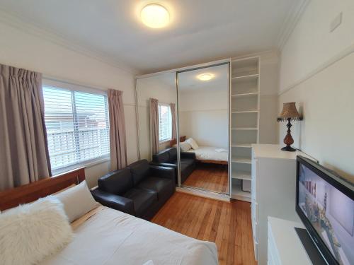 a bedroom with a bed and a couch and a mirror at Sunbury Central in Sunbury