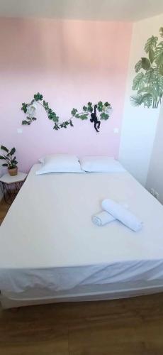 - une chambre avec un lit blanc et des fleurs sur le mur dans l'établissement Appartement vue panoramique au domaine et golf de pont royal, à Mallemort