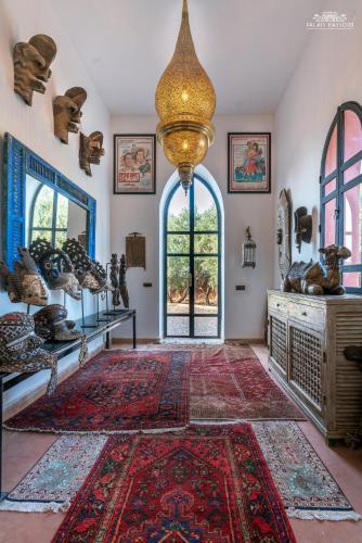 a room with a large rug and a chandelier at Palais Hassoun Marrakech in Oulad Snaguia