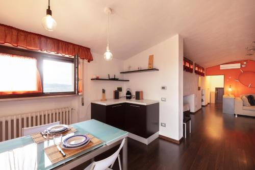 uma cozinha e sala de estar com uma mesa num quarto em Mansarda vista mare em Massa Marittima