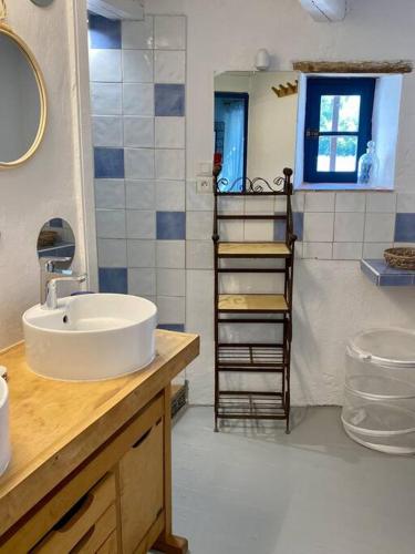 La salle de bains est pourvue d'un lavabo et d'une échelle de serviettes. dans l'établissement Montjoïa Le gîte bleu, au Thor