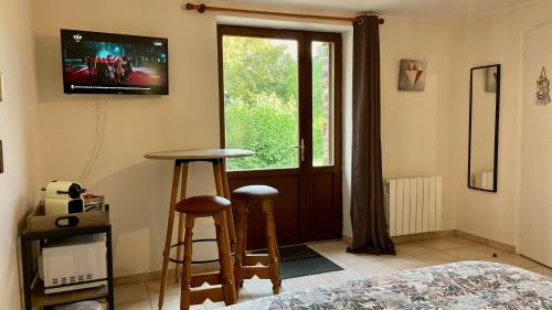 1 dormitorio con 1 cama y TV en la pared en Chambres Les Tilleuls, en Poullaouen