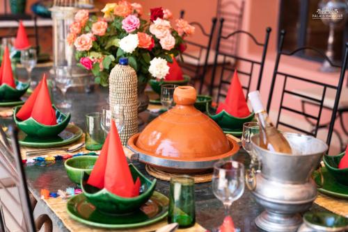a table with red and green plates and vases at Palais Hassoun Marrakech in Oulad Snaguia