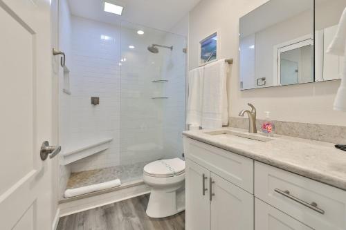 a white bathroom with a toilet and a sink at 100 steps to beautiful Indian Rocks Beach, oceanside, 2 bedroom updated condo in Clearwater Beach