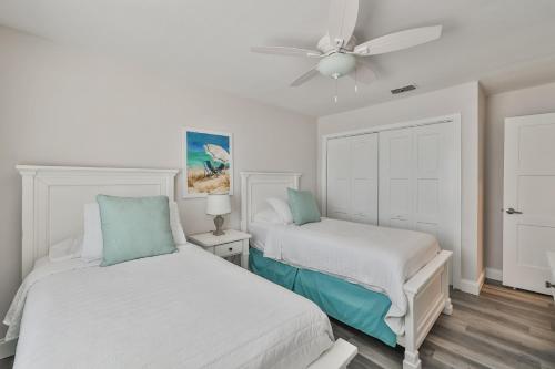 a bedroom with two beds and a ceiling fan at 100 steps to beautiful Indian Rocks Beach, oceanside, 2 bedroom updated condo in Clearwater Beach
