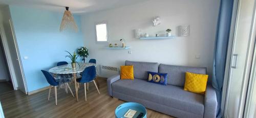 a living room with a couch and a table at Appartement vue panoramique au domaine et golf de pont royal in Mallemort