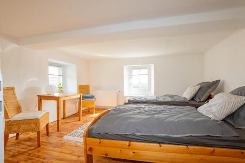 a bedroom with two beds and a desk at Ferienhaus Schneifel in Auw