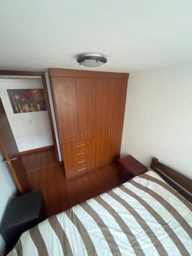 a bedroom with a bed and a wooden cabinet at El Bosque in Bogotá