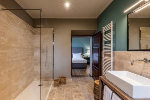 een badkamer met een wastafel en een douche bij Palazzo Massaini - Le Scuderie in Pienza