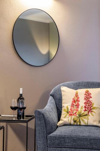 a blue chair with a pillow and a round mirror at Palazzo Massaini - Le Scuderie in Pienza
